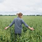 Woman standing in a field of tall green slender plants