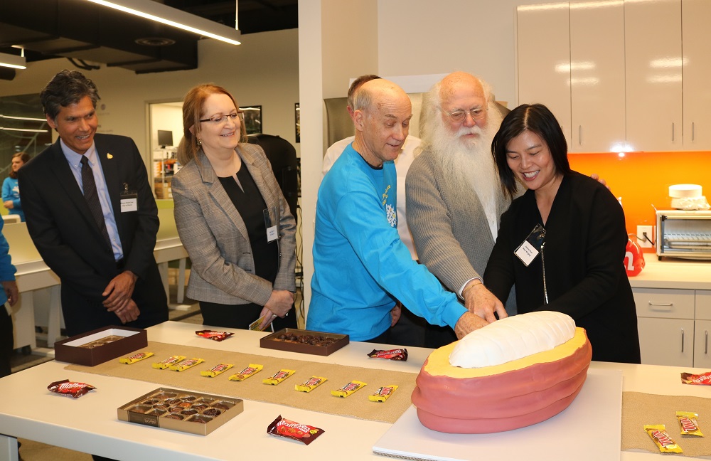 Guests at the opening of the new Mars research facility were treated to chocolate cake, shaped like a giant cacao pod. From left, Mayor Brett Lee, UC Davis Dept. Chair Gail Taylor, David Mackill and Howard-Yana Shapiro (both with Mars Wrigley and adjuncts at UC Davis), and Joanna Hwu, Senior Director of Cacao R&D Operations. photo Ann Filmer/UC Davis