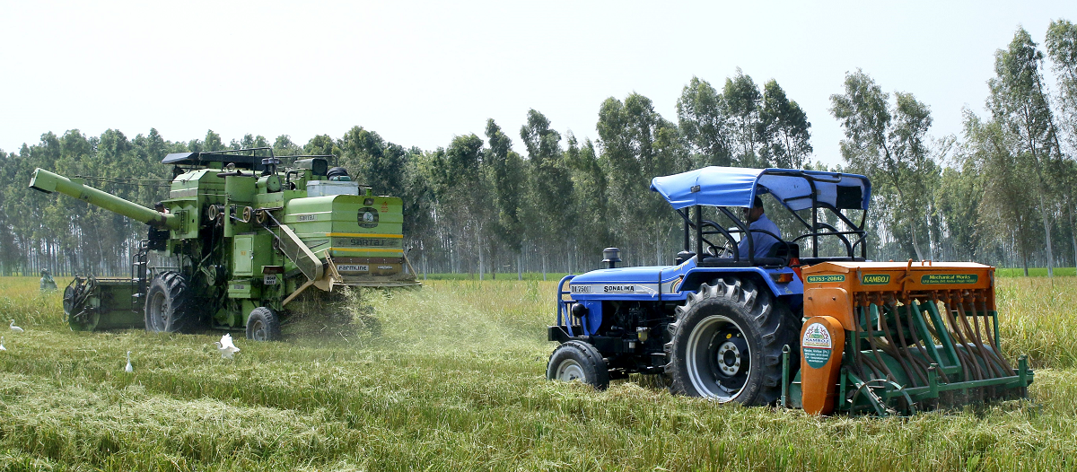 A combine harvester equipped with the Super SMS (left) harvests rice while a tractor equipped with the Happy Seeder is used for direct seeding of wheat. (photo Sonalika Tractors)
