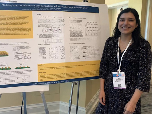 A young woman standing by a research poster