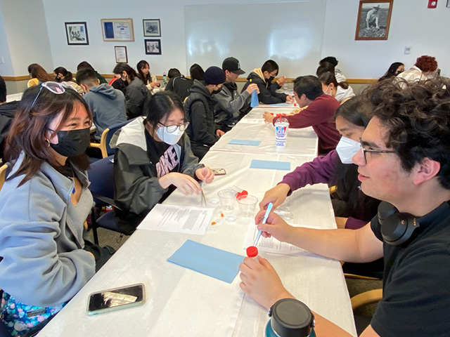 Students at tables with test tubes