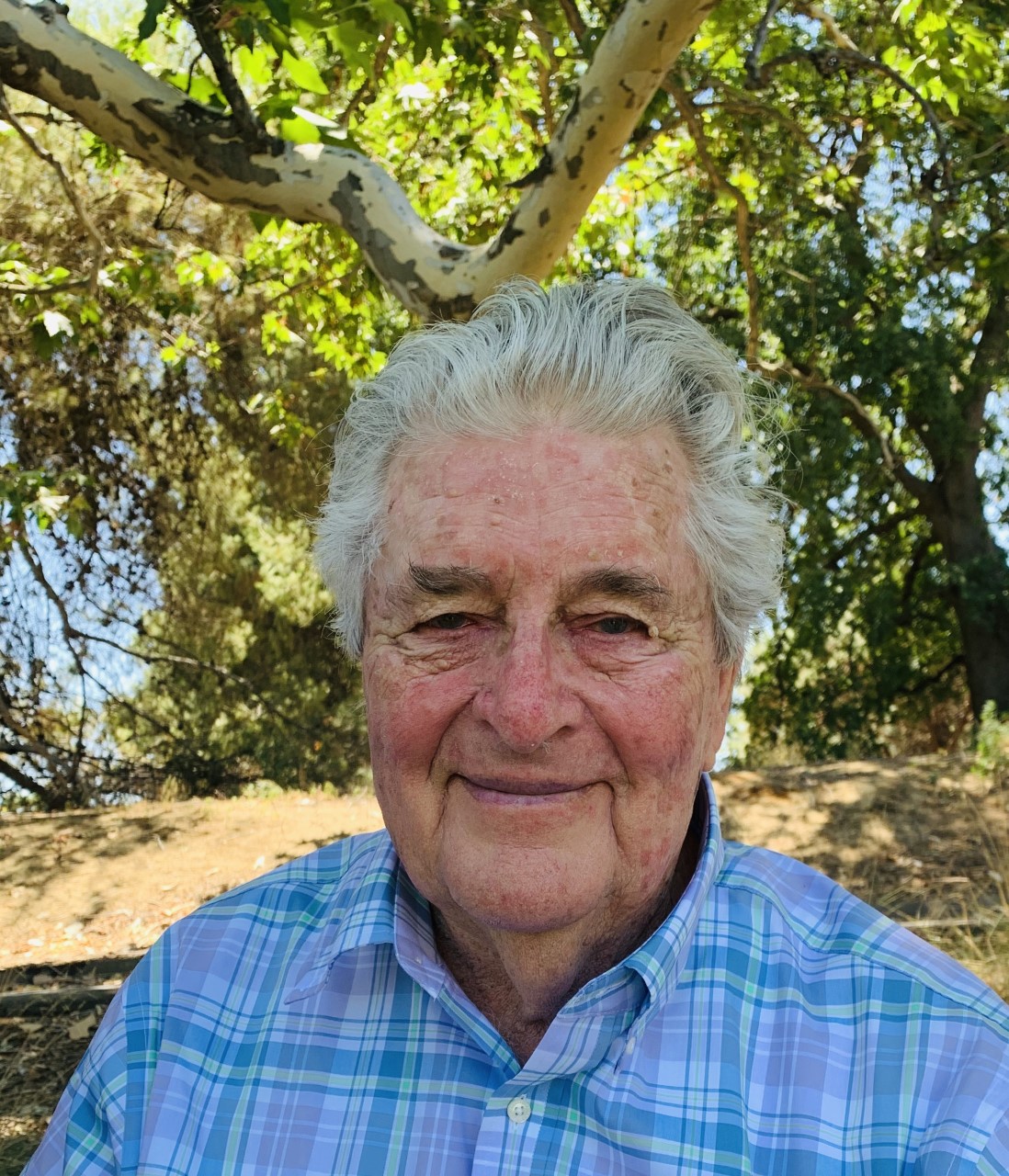 Older man, with trees in the background