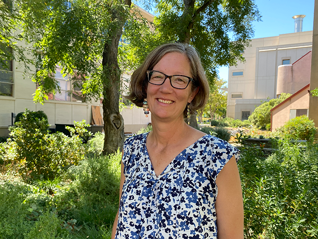 A woman in a tree-filled courtyard