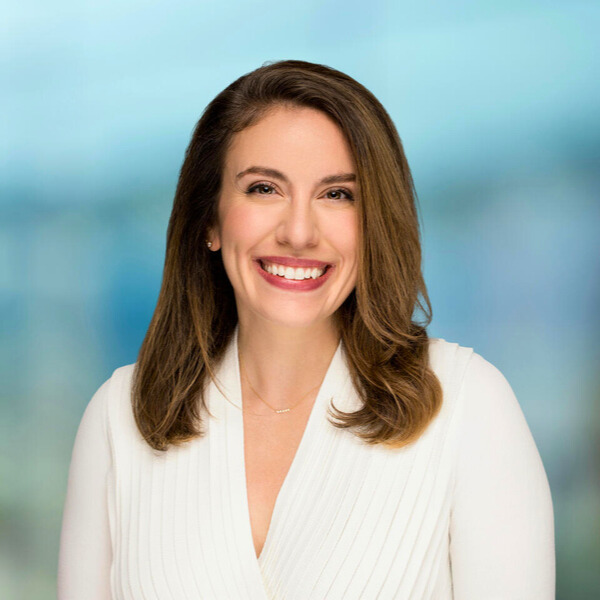 Woman smiling. White jacket. 