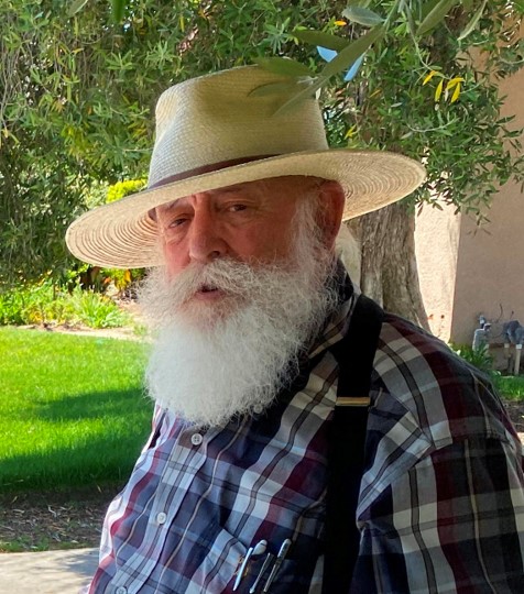 An older man with a white beard wearing a hat