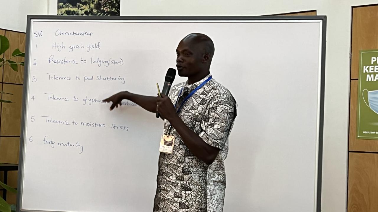 Man holding a microphone and standing at a whiteboard