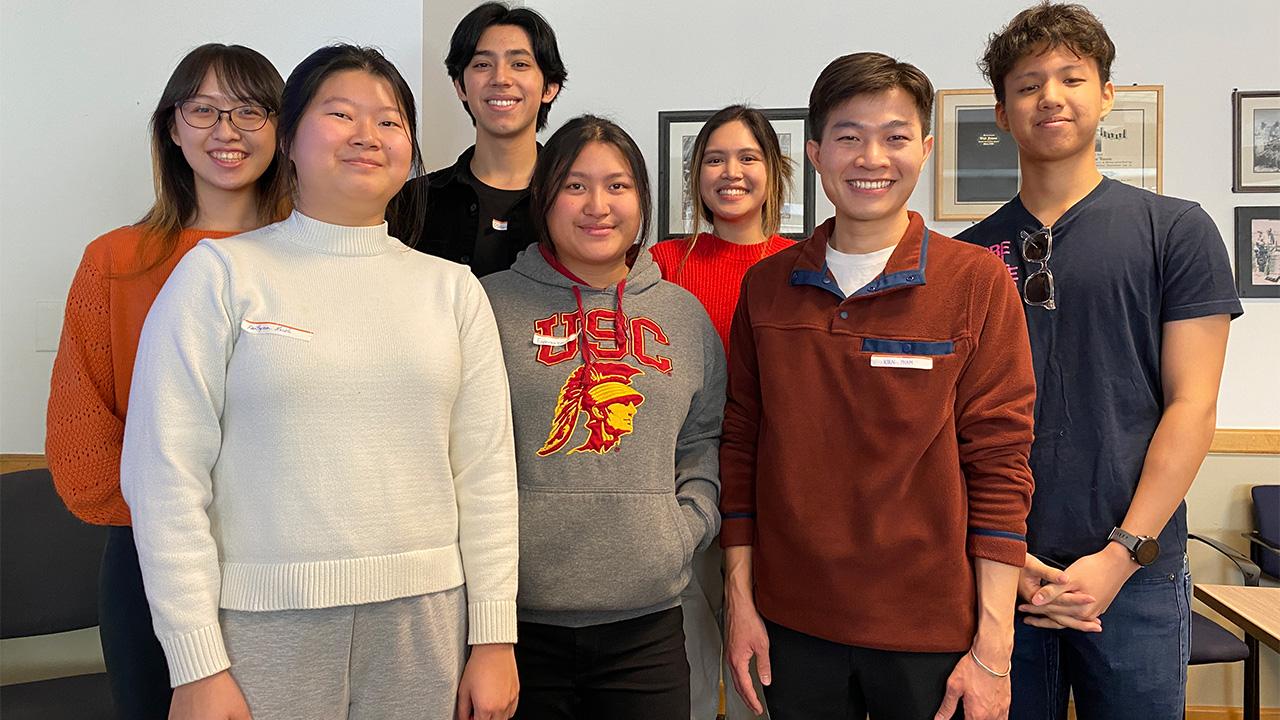 Seven young adults standing and smiling