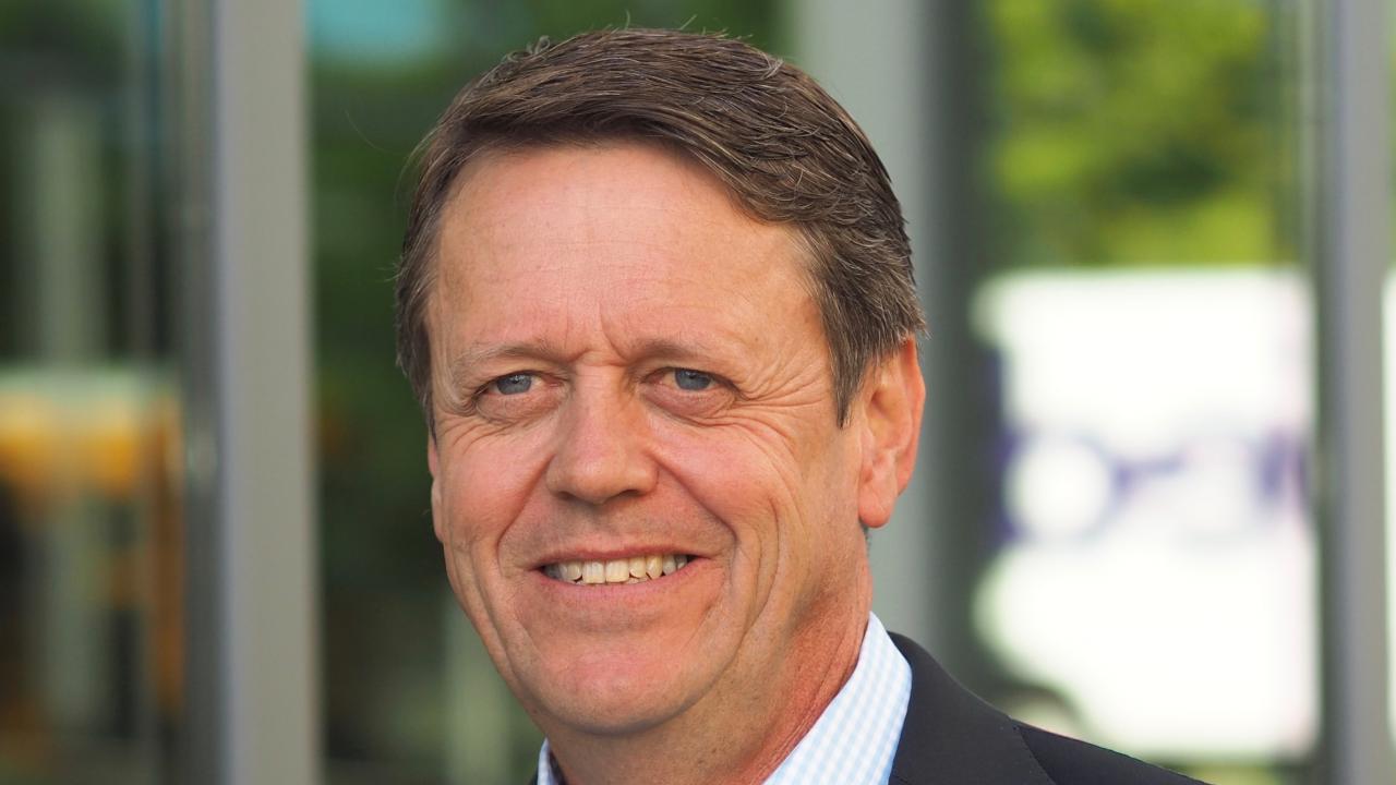 Headshot of Patrick Brown with a building as the background 