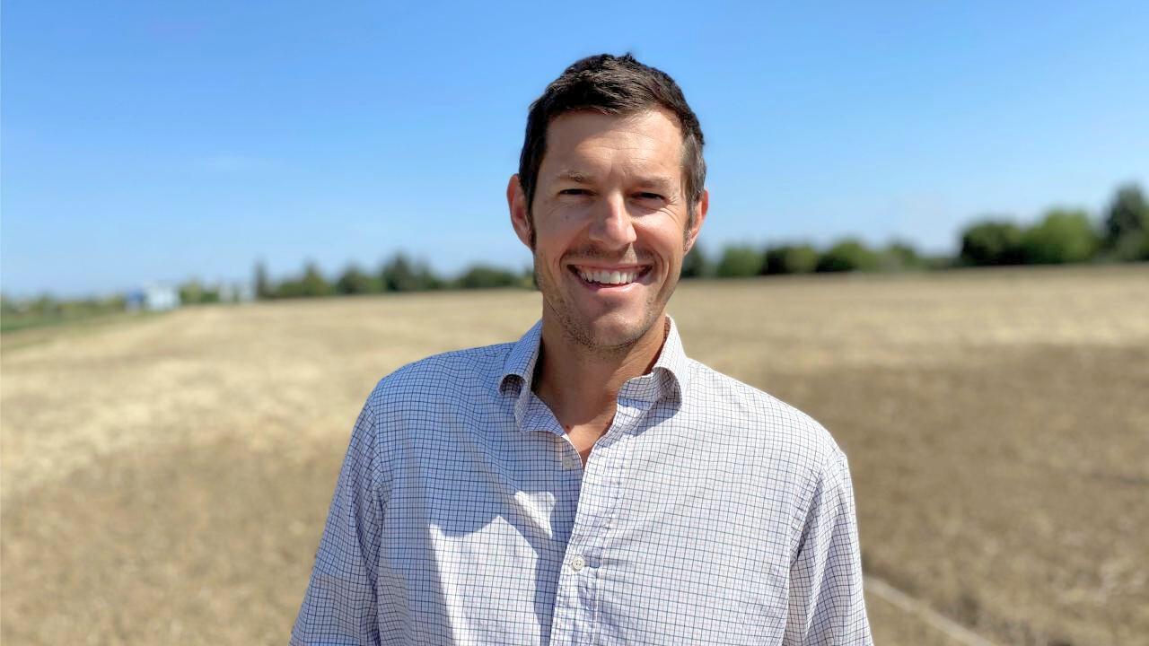 Man smiles in broad field
