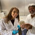 Woman and man wearing lab coats and holding small round glass dishes