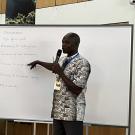 Man holding a microphone and standing at a whiteboard