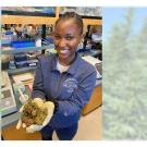 Woman in a lab holding dried leaves in her hand