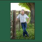 Man standing by a tree on a grassy area