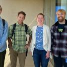 Four people standing on a balcony