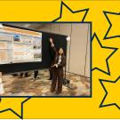 Young woman with arms stretched proudly toward a scientific poster that reads, “Evaluating bacterial diversity and pest control efficacy of steam disinfestation treatments in the Salinas Valley spinach and lettuce fields.”