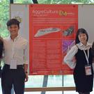 Four young people standing on either side of a scientific presentation poster