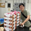 A man in a room with boxes of fruit