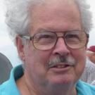 Lynn Gallagher, professor emeritus and barley breeder at the University of California, Davis, wears a half smile in a close-up portrait