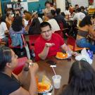 Young people sitting at many tables, laughing and talking.