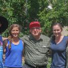 five younger people standing in a line outside with an older man in the middle