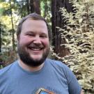Man in front of redwood trees