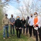 Provost Croughan stands in an orchard row with representatives from the Department of Plant Sciences 