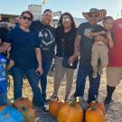 A large family with several large, orange pumpkins.