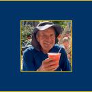 Older man smiling and holding a beverage.