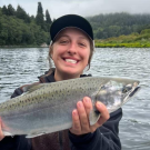 Allison Rietman holding a fish on a lake. 