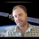 Troy Magney, seen from chest up, talks over Zoom. His background image is of a satellite orbiting Earth.