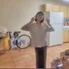 Young woman wearing a white shirt and black pants in nearly empty apartment